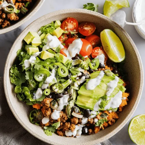 The Best Sweet Potato Taco Bowl 2 Overhead view of a vibrant sweet potato taco bowl with avocado, black beans, and creamy sauce on a marble surface.