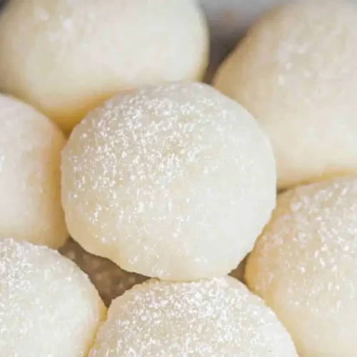 Easy Homemade Mochi: A 4-Ingredient Recipe for Chewy Perfection 2 Soft homemade mochi dusted with starch, showcasing chewy Japanese sweet rice cakes arranged in a bowl.