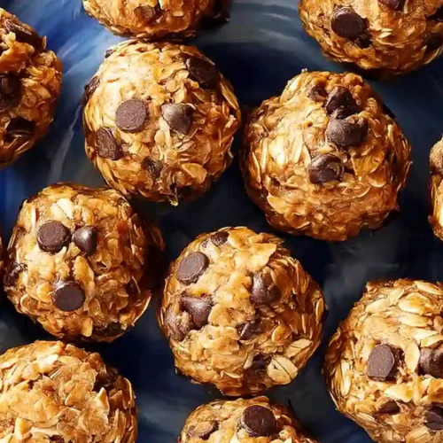The BEST Peanut Butter Protein Balls Recipe 3 Peanut butter protein balls recipe with oats and chocolate chips arranged on a blue plate.
