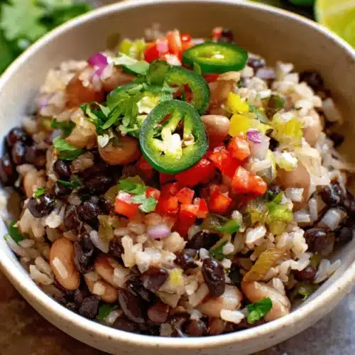 Quick & Easy Black Bean and Rice Bowl (Vegan, Healthy, & Budget-Friendly) 2 Vibrant Black Bean and Rice Bowl topped with fresh salsa, cilantro, and sliced jalapeños.