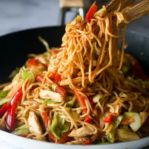 Close-up of delicious chicken yakisoba being served from a pan.